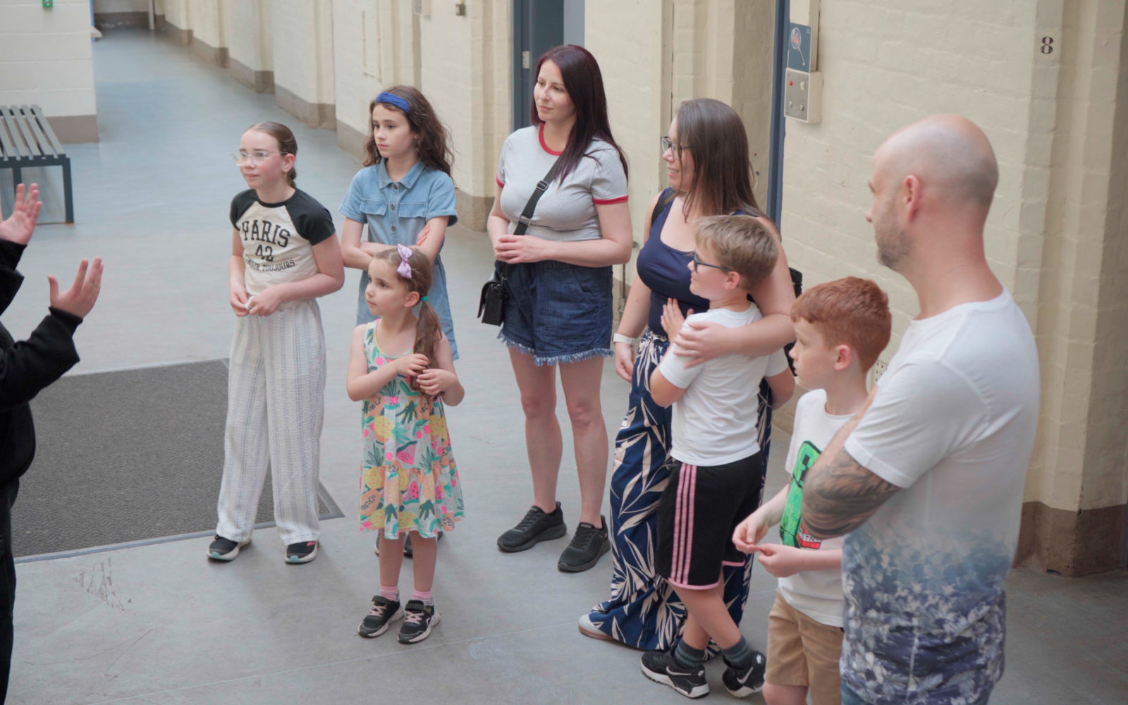 A family exploring a prison wing with an Ex Officer on A Guided Tour